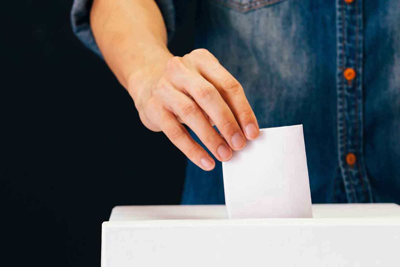 Hand putting ballot in ballot box